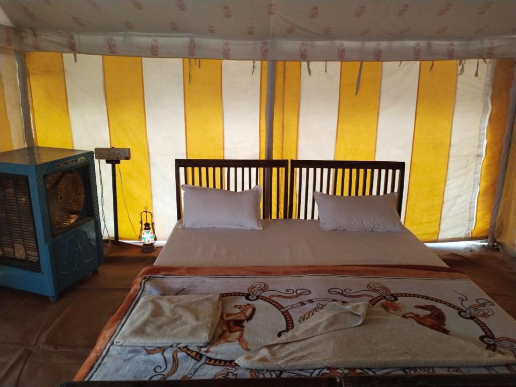 a bedroom with a bed and a fireplace at Jaisalmer Safari Base & Camp in Khuri