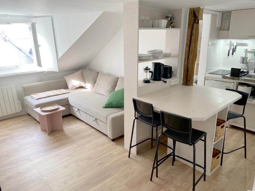 Ce petit appartement comprend une table et un canapé. dans l'établissement Le cocon perché entre l'Opéra et les Tuileries, à Paris
