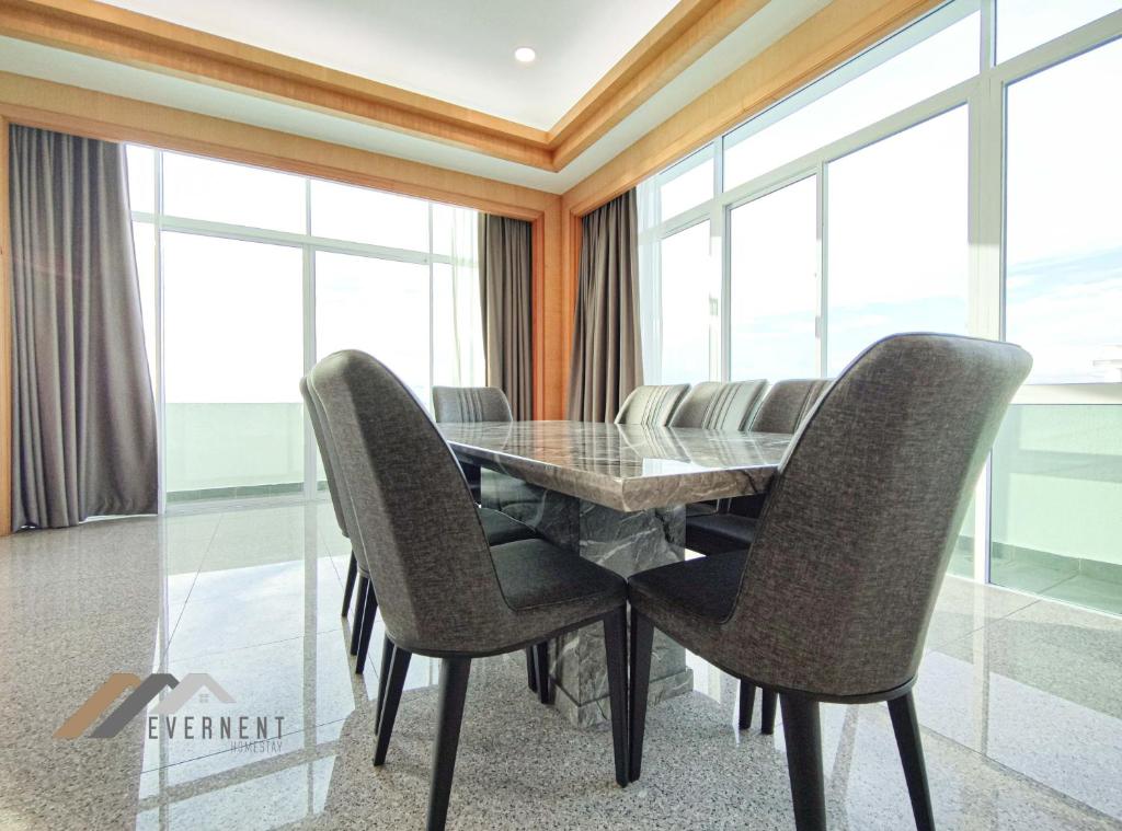 a dining room with a glass table and chairs at Bay Resort Penthouse by Evernent in Miri