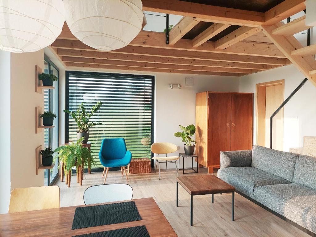 a living room with a couch and chairs at Small house in a nature park in Log pri Brezovici