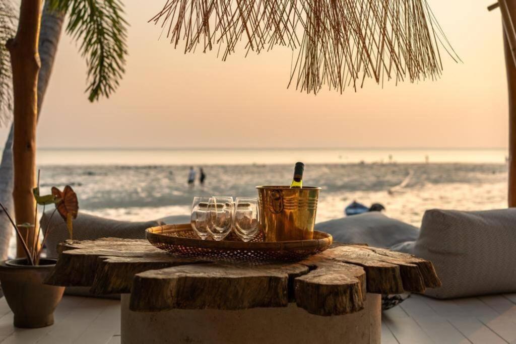 una mesa en la playa con gafas en Villa Le cerf doré, en Hinkong