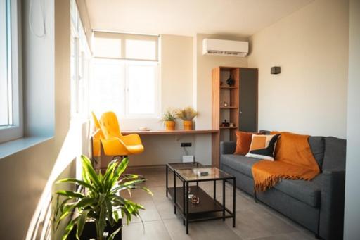 ein Wohnzimmer mit einem Sofa und einem Tisch in der Unterkunft CENTRAL OLD TOWN- LADADIKA APARTMENT in Thessaloniki