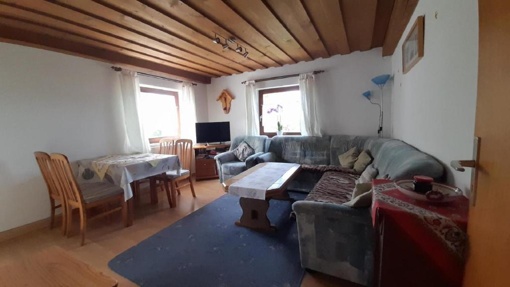 a living room with a couch and a table at Bauernhof Madlhof in Neuschönau