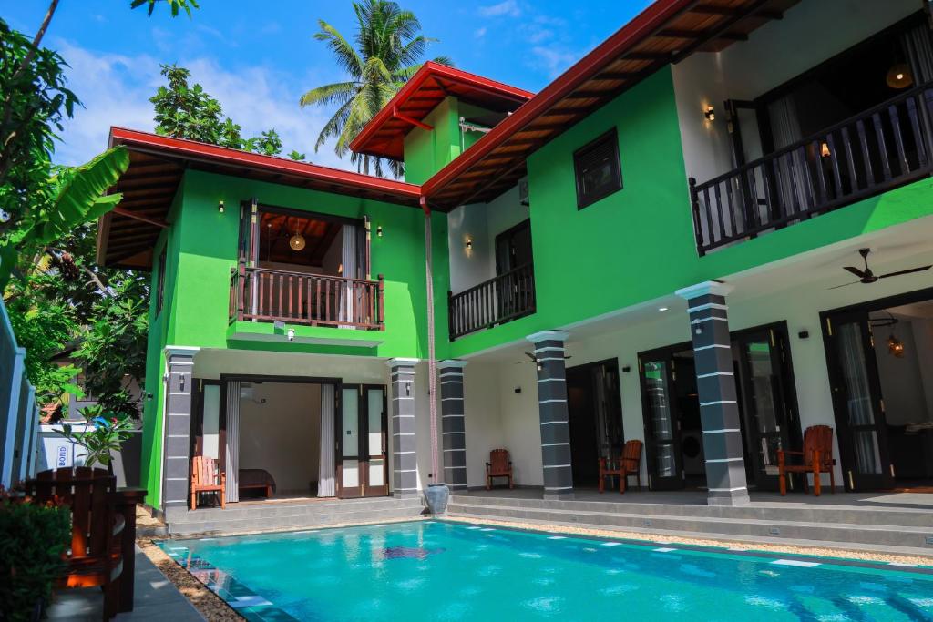 a house with a swimming pool in front of it at IBSON Villa - 02 Hikkaduwa with 4 Bedrooms & Salt Water Swimming Pool in Hikkaduwa