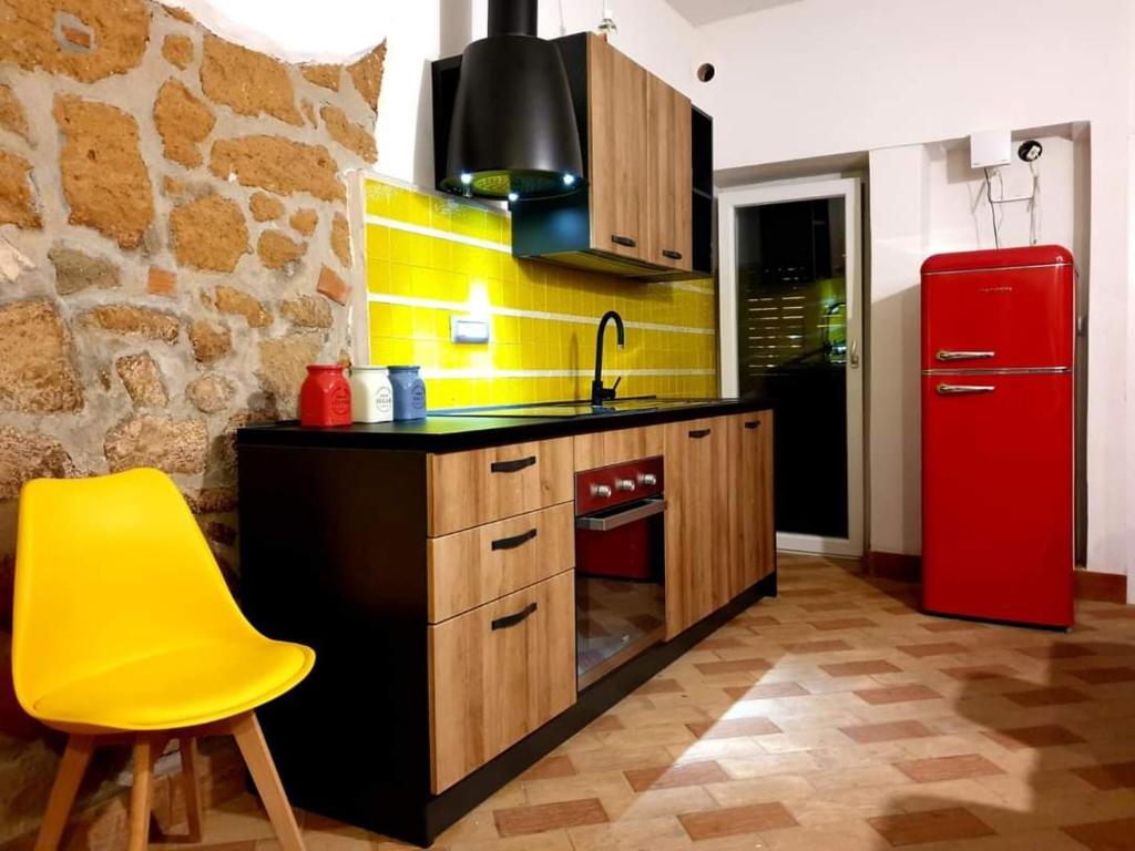 cocina con nevera roja y silla amarilla en Casa Mattia Centro Storico, en Cisterna di Latina