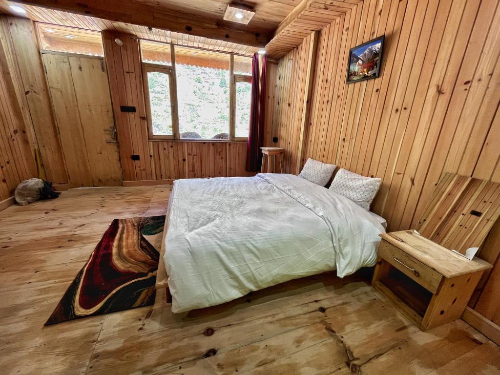 Harsil的住宿－Golden heritage dharali，木制客房内的一间卧室,配有一张床