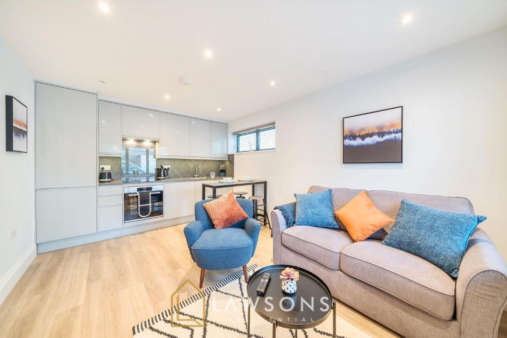 a living room with a couch and chairs and a kitchen at Watt a Stay I Free EV Parking in Windsor