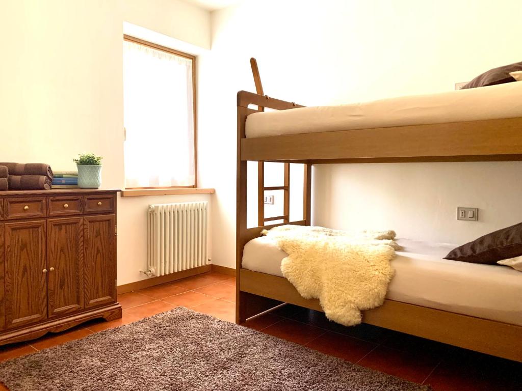 a bedroom with two bunk beds and a rug at Cima de' Piazzi Apartment 2 in Isolaccia