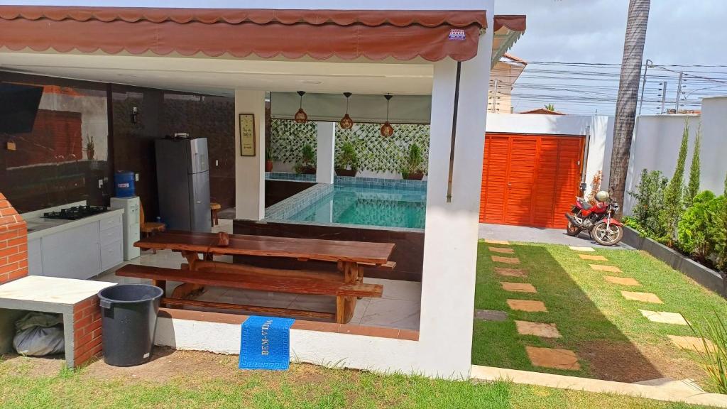 uma casa com um banco e uma piscina em Cantinho da Praia do Meio em São José de Ribamar