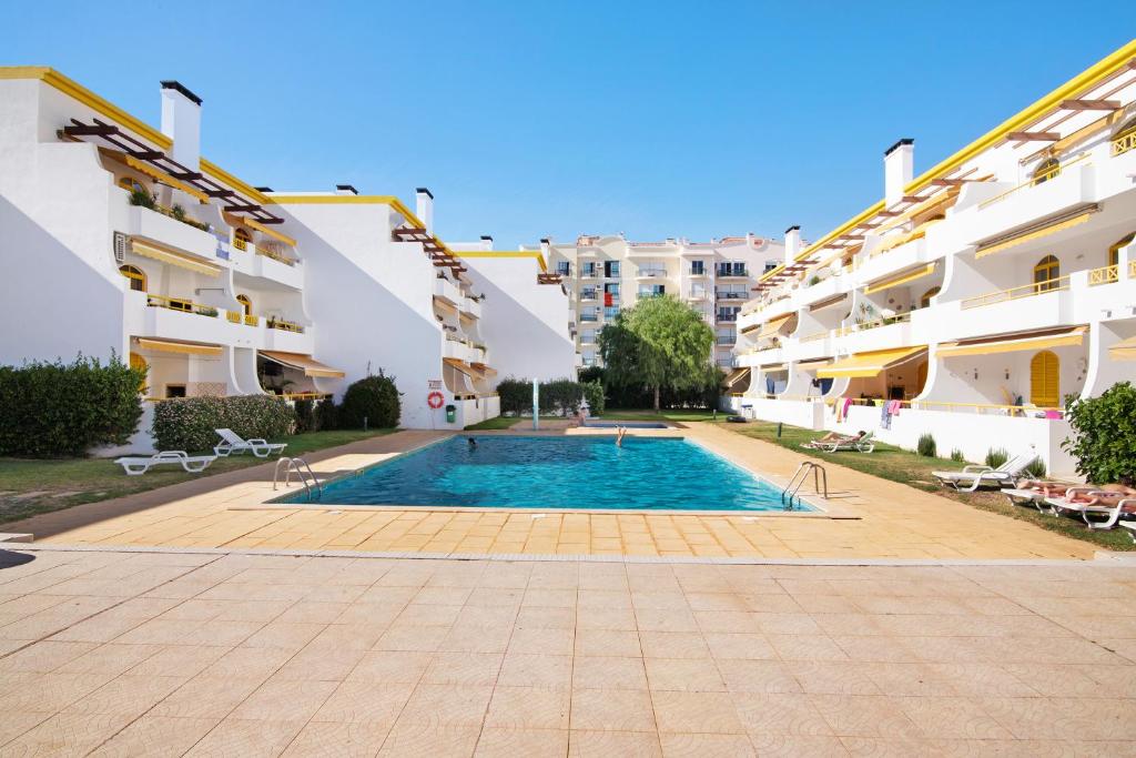 a swimming pool in front of some apartment buildings at Vila Mar Azul in Quarteira