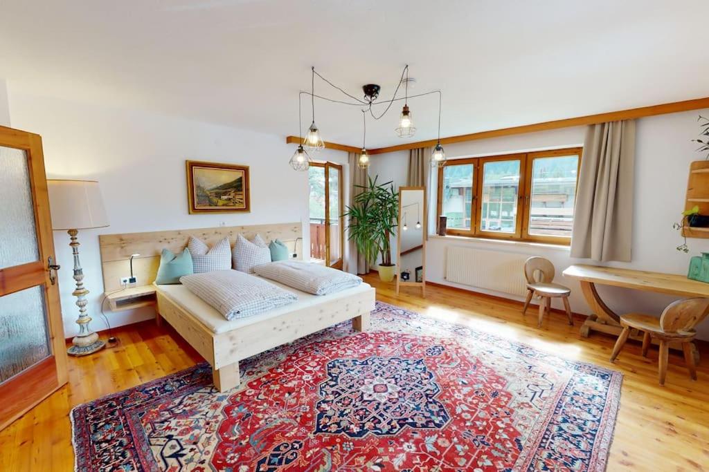 sala de estar con cama y alfombra en Haus Alberto - Haus mit 2 Ferienwohnungen, en Ötztal-Bahnhof