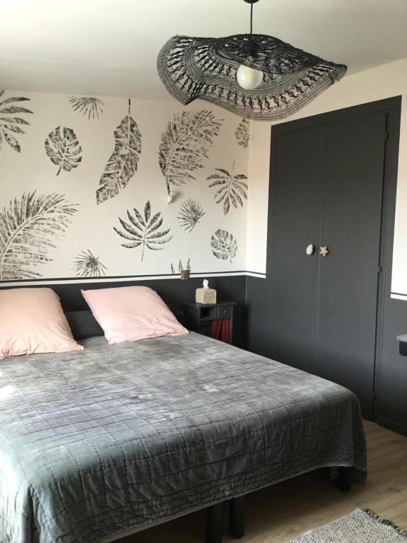 ein Schlafzimmer mit einem Bett und einer Wand mit Pflanzen in der Unterkunft BnB Montacutain in Montaigu-Vendée