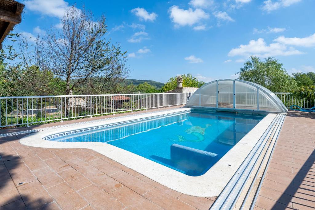 a swimming pool with a greenhouse next to a house at Can tronc in Querol