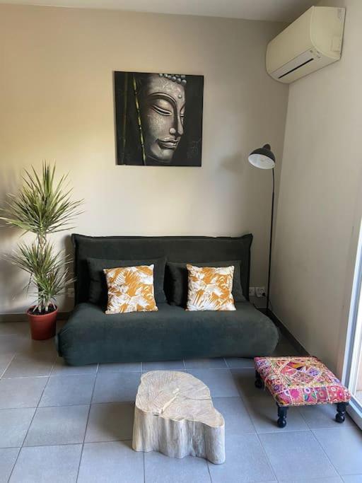 un salon avec un canapé vert et une table dans l'établissement Appartement cosy climatisé dans résidence fermée, à Sarrola-Carcopino