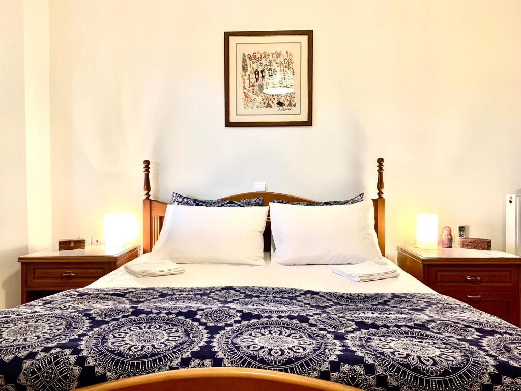 a bedroom with a bed with a blue and white comforter at Aggelos and Thisbe Chania Suburbs Sea View Guest House in Chania Town