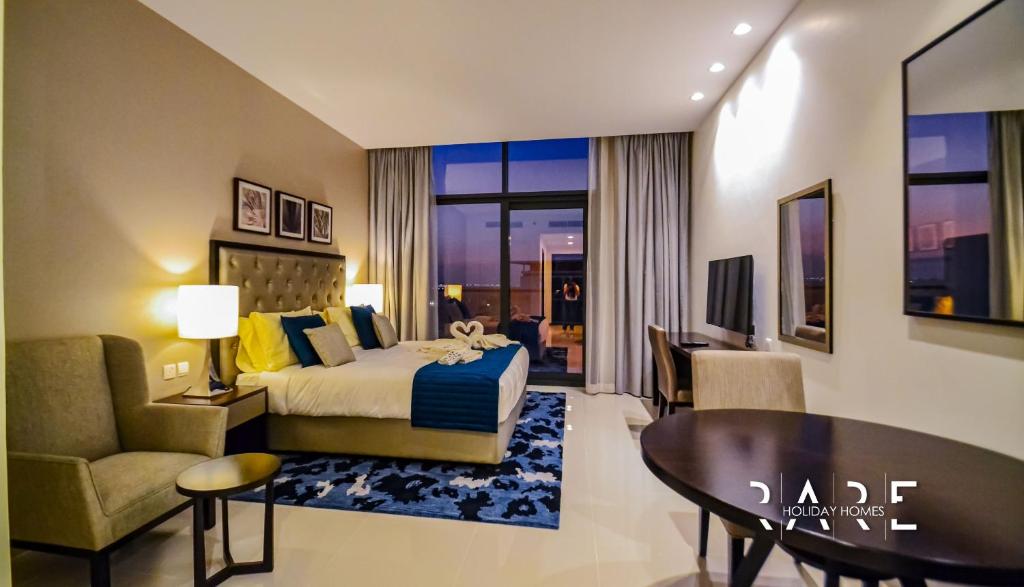um quarto de hotel com uma cama e uma sala de estar em Rare Holiday Homes offers Luxurious apartment with desert View - Near Expo City - R451 em Dubai