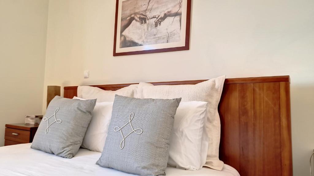 Un dormitorio con una cama con almohadas encima. en Lucy Sweet Home by LovelyStay, en Caniço