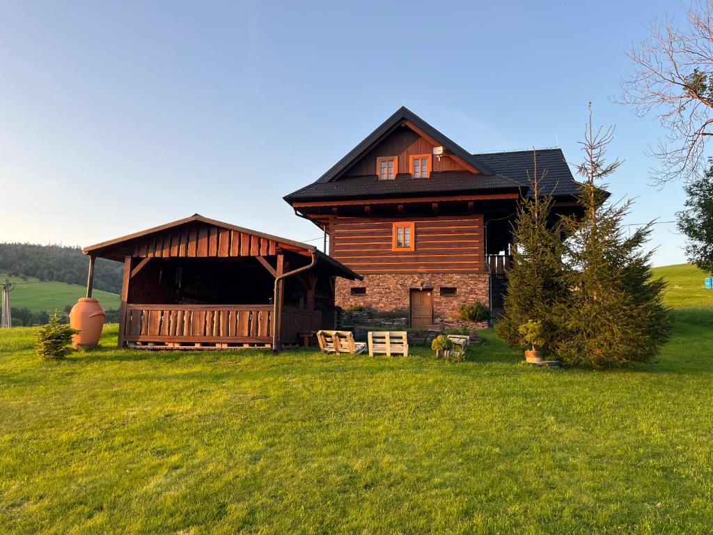 a large wooden house in a field of green grass at Chalupa Daniel in Ždiar