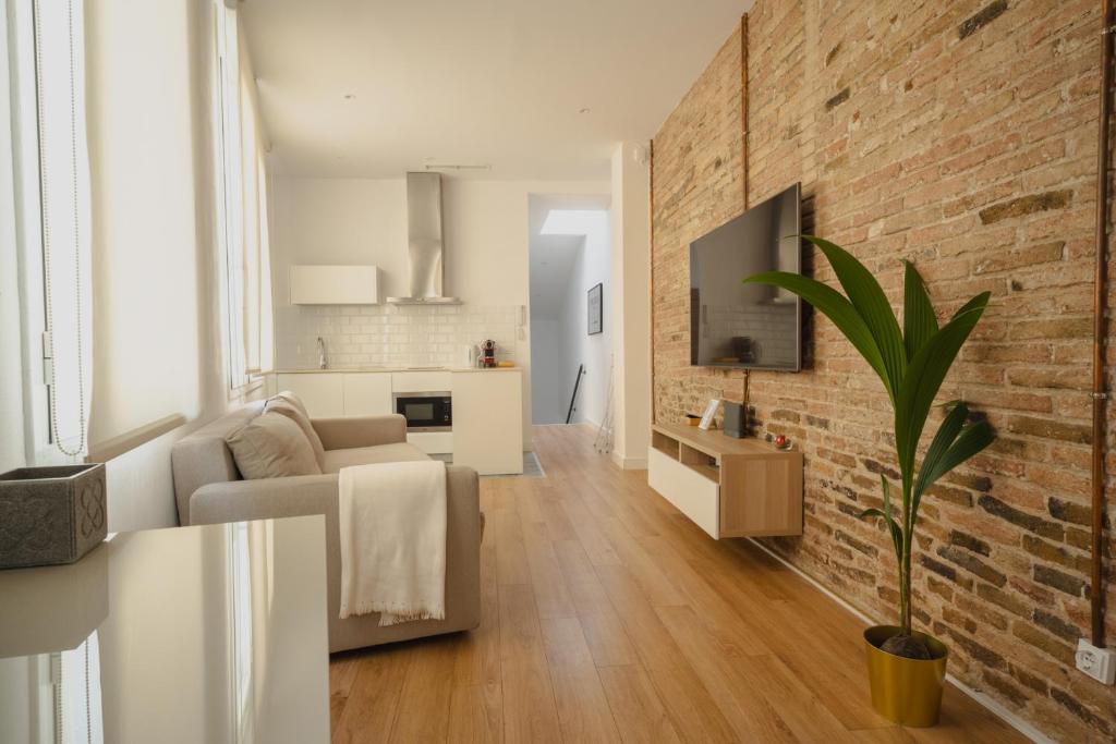 a living room with a couch and a brick wall at Villa Conde in Hospitalet de Llobregat
