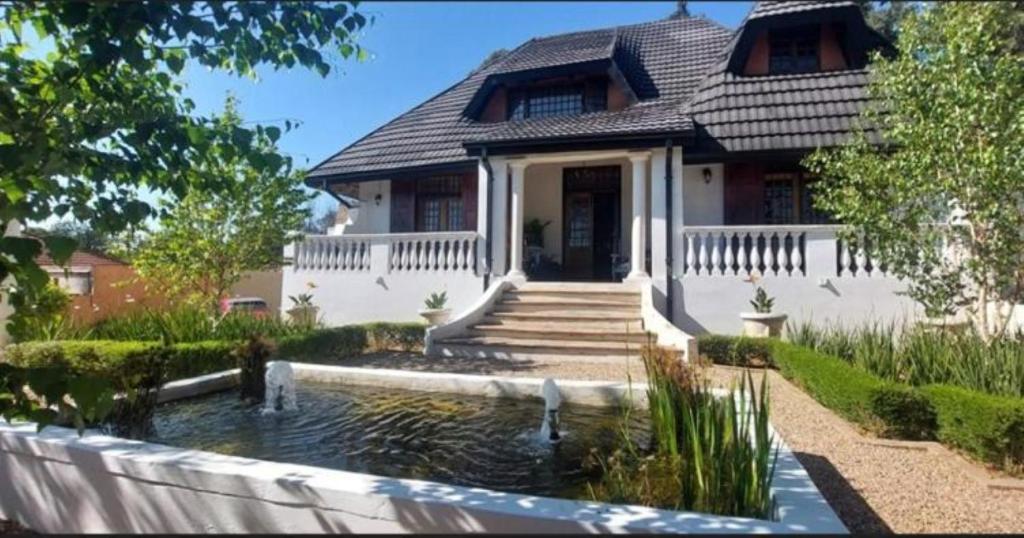 a house with a pond in front of a house at The Dauphin House in Johannesburg
