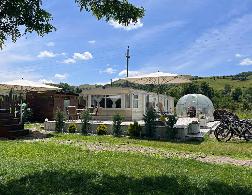 dom z parasolami i motocyklem przed nim w obiekcie Kinder Valley Morlaca Cluj w Klużu-Napoce