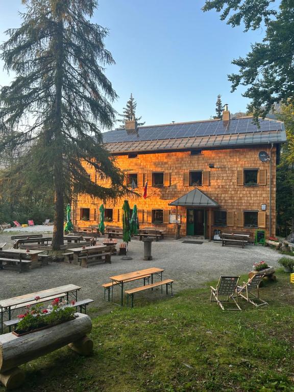 a large brick building with benches in front of it at Mountain hut Dom pod Storžičem in Tržič
