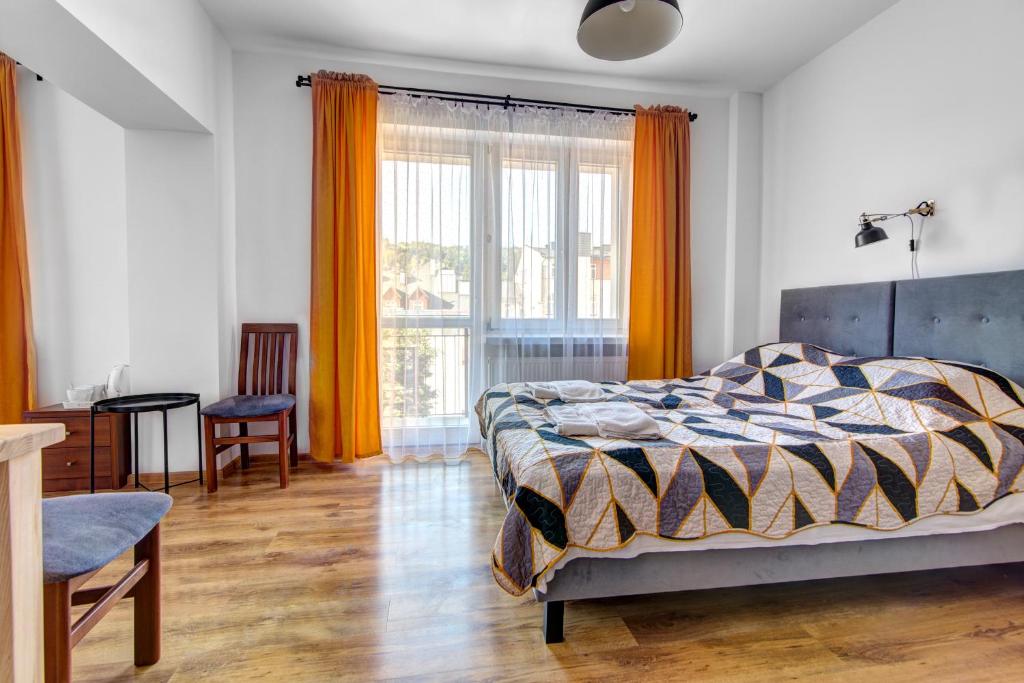 1 dormitorio con cama y ventana grande en Willa Wladyslaw - centrum Krynicy, parking w cenie!, en Krynica-Zdrój