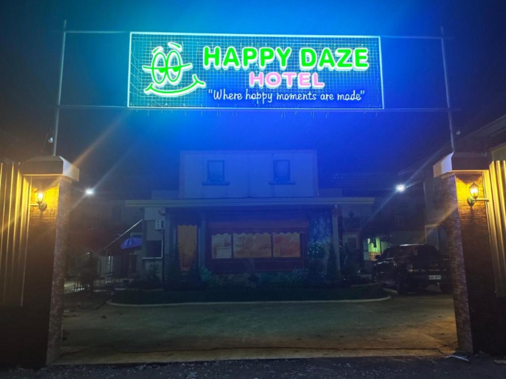 una señal para un feliz hotel de baile por la noche en Happy Daze Hotel Tagum, en Tagum