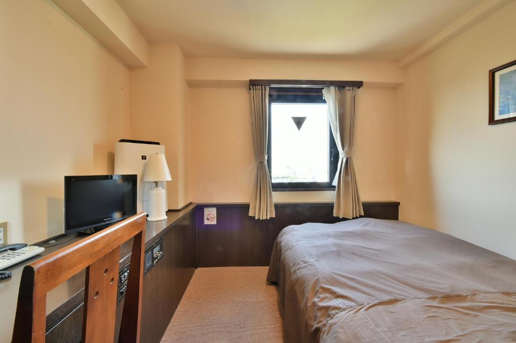 Postel nebo postele na pokoji v ubytování Suzuka Royal Hotel