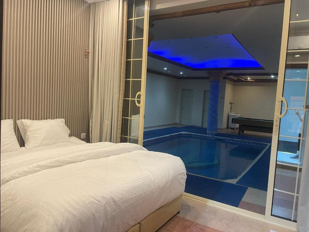 a bedroom with a bed and a swimming pool at شاليه سهم in Al Khobar