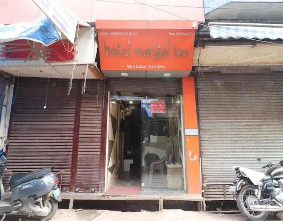 un front de magasin avec une moto garée à l'extérieur dans l'établissement The Mangal Inn by StayApart, à Haridwar