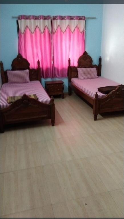 Postelja oz. postelje v sobi nastanitve ISKCON Pandharpur's Chandrabhaga Guest House
