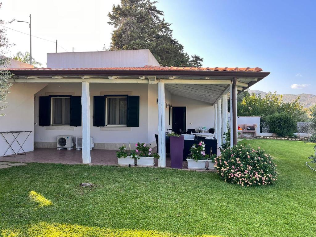 une maison blanche avec une terrasse couverte et une cour dans l'établissement Summer house, à Avola