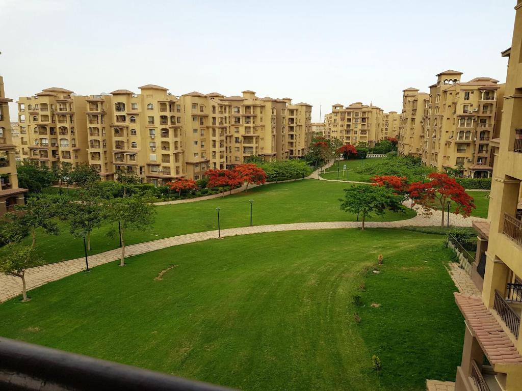 un parque en medio de una ciudad con edificios altos en شقة فندقية بإطلالة خيالية مكيفة بالكامل للايجار في مدينتي-Madīnat, en Madinaty