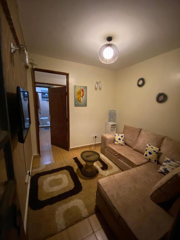 a living room with a couch and a tv at SAGE Apartments-South B in Nairobi