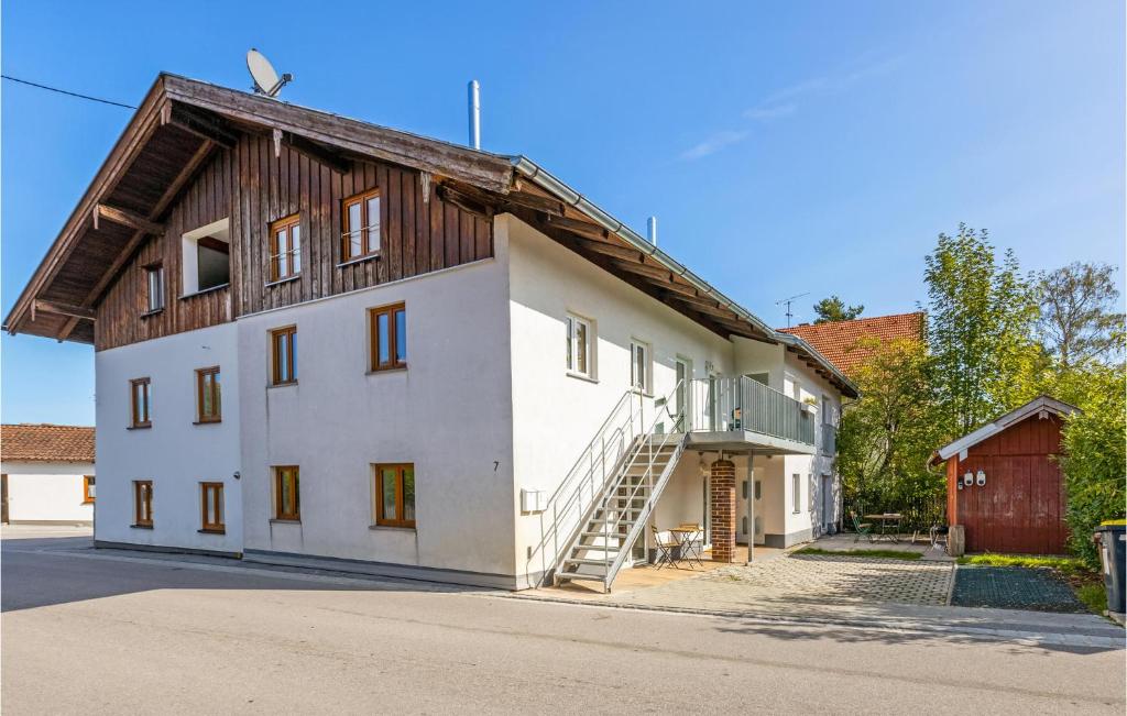 a large white building with a wooden roof at Pet Friendly Apartment In Mnsing With Wifi in Münsing