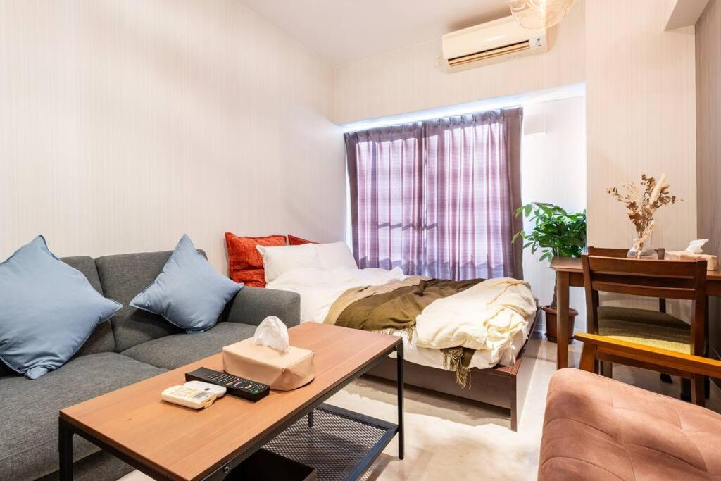sala de estar con sofá y cama en #803 Opening sale! Private rental Osaka city central Has the longest shopping street and you can enjoy the real Osaka, which has not yet become a tourist destination, en Osaka