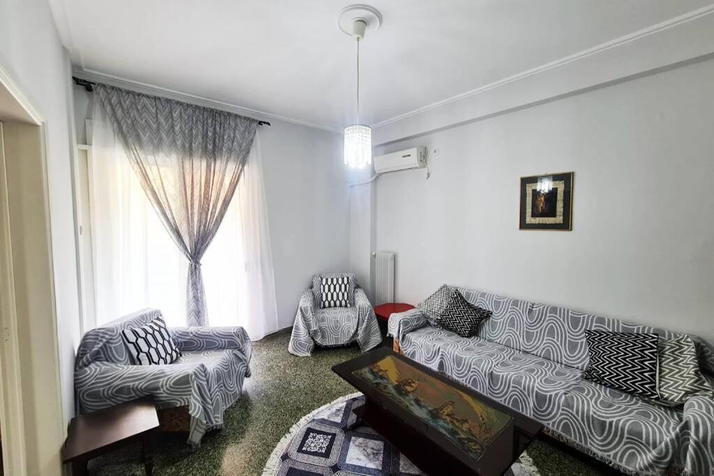 a living room with a couch and chairs and a window at Sunny Dream House in Piraeus