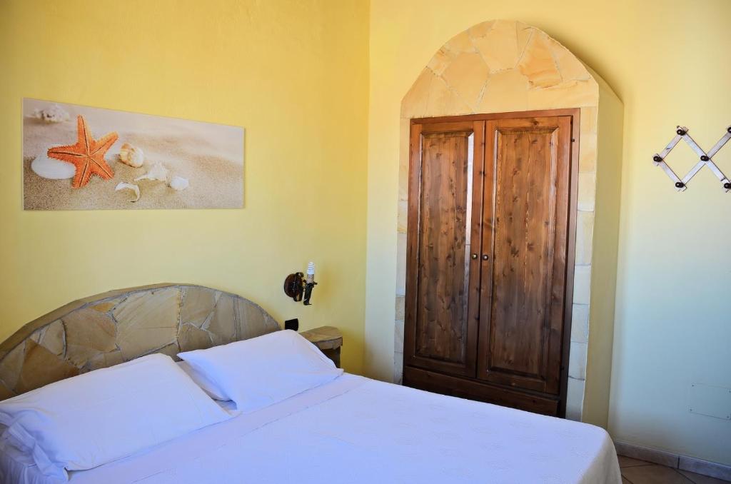 a bedroom with a bed and a wooden door at Appartamenti La Risacca in Lampedusa