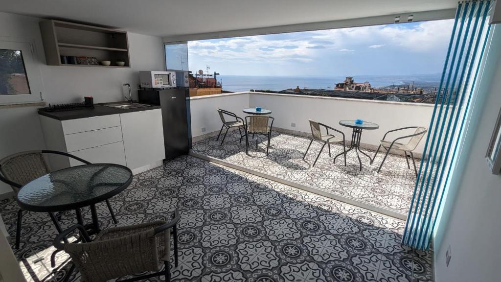 een keuken met een balkon met een tafel en stoelen bij Opuntia Charming Rooms in Taormina