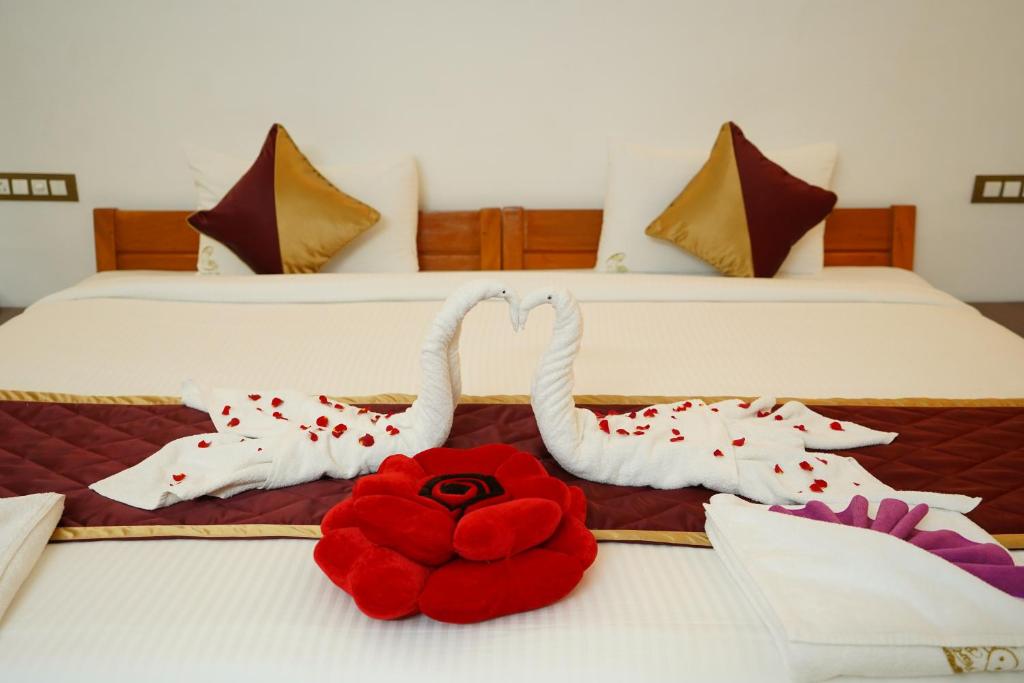 two swans made out of towels on a bed at Pearl bell Villa in Pondicherry