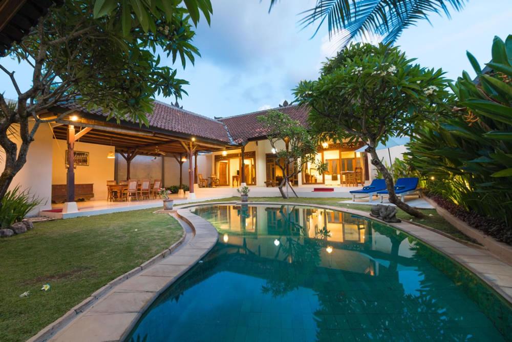 a swimming pool in the backyard of a house at Royal Indah Bali Villas in Seminyak