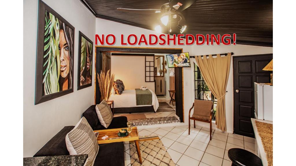 a living room with a no loadblocking sign on the wall at Hello Sunshine Self Catering Studio Apartments in Nelspruit