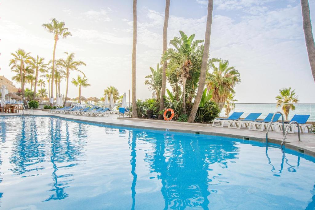 einen Pool in einem Resort mit Palmen in der Unterkunft Hotel Best Benalmadena in Benalmádena