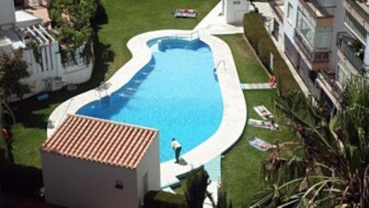 widok na basen z mężczyzną stojącym obok niego w obiekcie ALBAIDA II 6i MENYBER w mieście Nerja