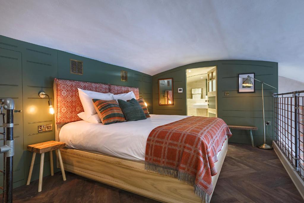 1 dormitorio con 1 cama grande y paredes verdes en Shirehall Apartments en Holt