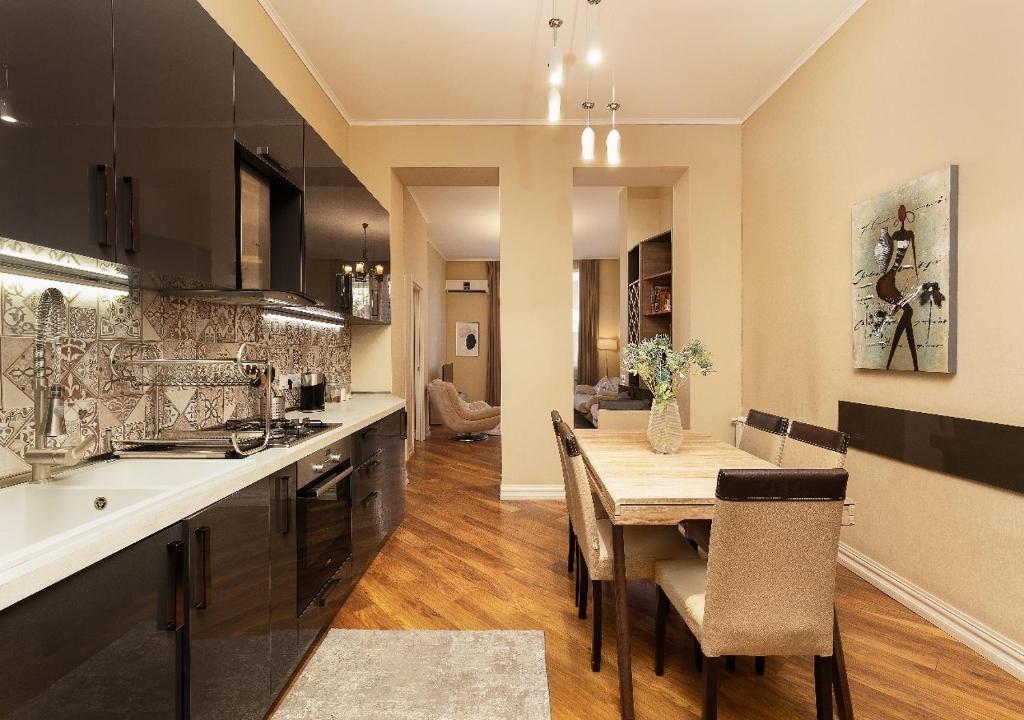 HD Dream Apartment في تبليسي: مطبخ مع طاولة وغرفة طعام