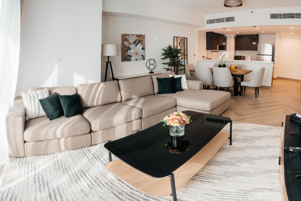 a living room with a couch and a table at LUXE 2BR at 1 RESIDENCES WASL NEAR METRO STATION in Dubai
