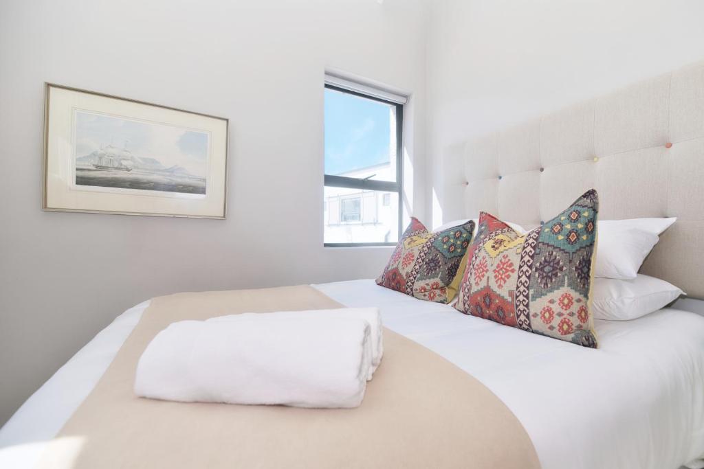 a white bedroom with a white bed with pillows at Agulhas Seabreeze, tip of Africa in Agulhas