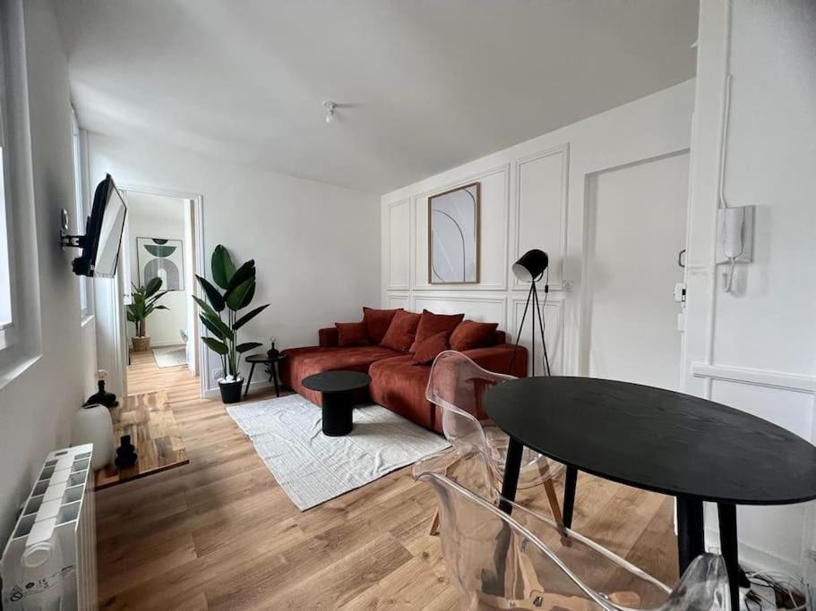 un salon avec un canapé rouge et une table dans l'établissement Appartement cosy cœur de ville et gare, à Angers